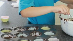 stock-footage-young-boy-baking-cup-cakes-with-his-grandmother-in-the-kitchen